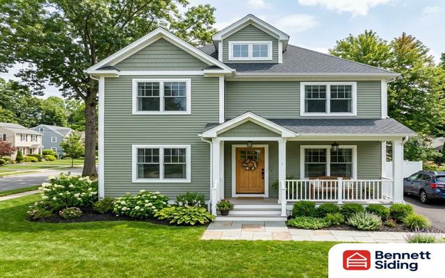 Two-story green house with front porch, lawn, and driveway car – siding gallery, Angier, NC